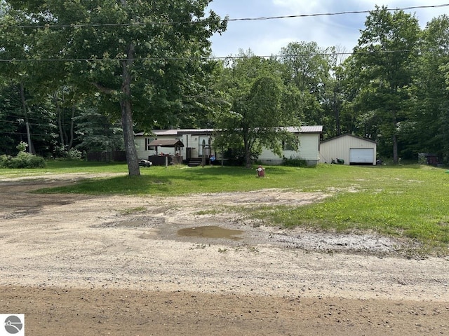 view of yard featuring a garage and an outdoor structure