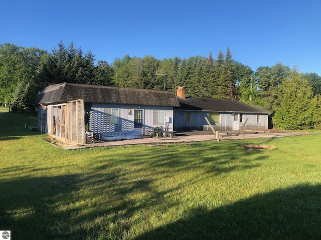 4472 Crescent Beach Rd, Onekama, MI 49675 - back of property with a wooded view, a yard, a deck, and a chimney