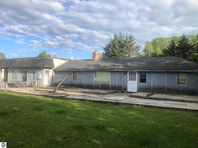 4472 Crescent Beach Rd, Onekama, MI 49675 - back of property featuring a chimney, a wooden deck, and a lawn