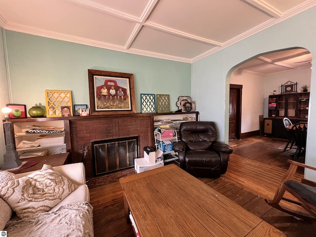 living room featuring coffered ceiling, dark wood-type flooring, and a brick fireplace