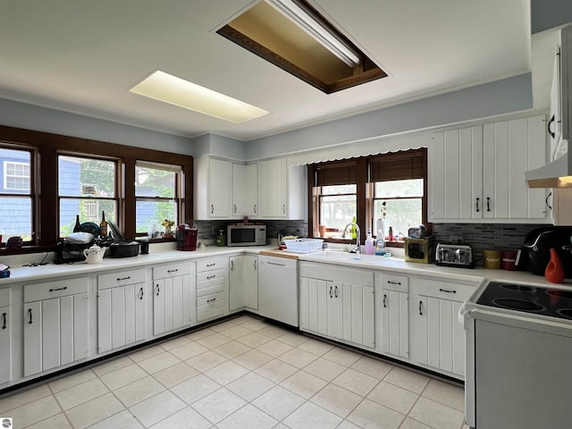 kitchen featuring backsplash, white cabinetry, sink, and white dishwasher