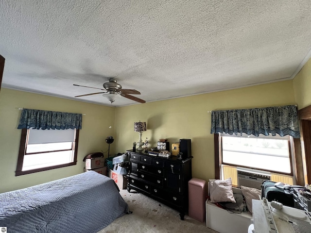 carpeted bedroom featuring ceiling fan and a textured ceiling