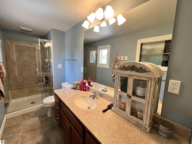 bathroom featuring vanity, toilet, an enclosed shower, and a notable chandelier