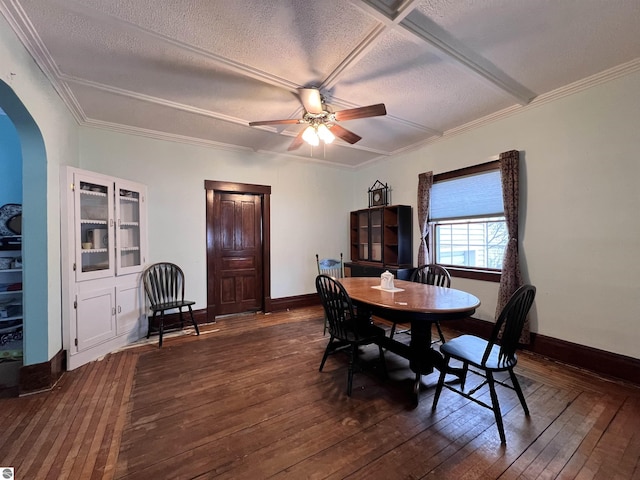 dining space with ceiling fan, crown molding, dark wood-type flooring, and a textured ceiling