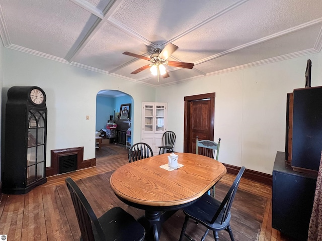 dining space featuring ceiling fan, dark hardwood / wood-style flooring, ornamental molding, and a textured ceiling