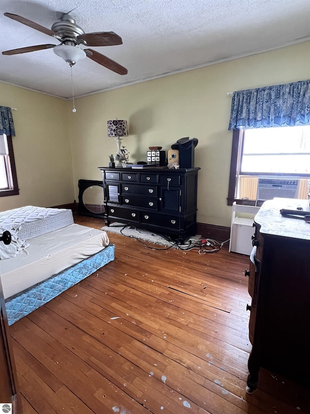 bedroom featuring a textured ceiling, dark hardwood / wood-style flooring, ceiling fan, and cooling unit