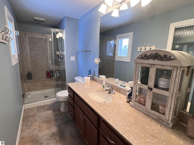 bathroom featuring vanity, ceiling fan, toilet, and a shower with shower door