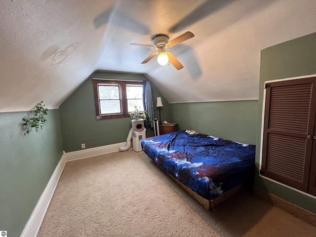 bedroom with carpet, ceiling fan, a textured ceiling, and vaulted ceiling