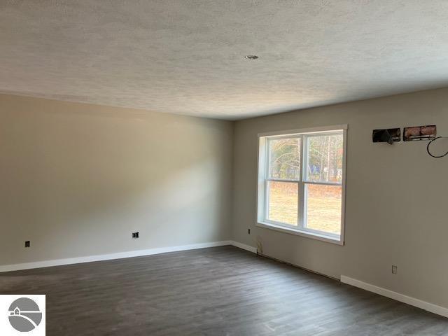 empty room with dark hardwood / wood-style flooring