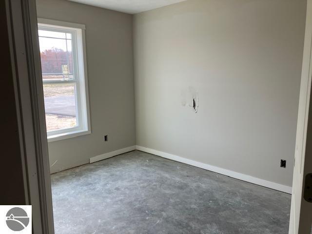 unfurnished room featuring concrete floors