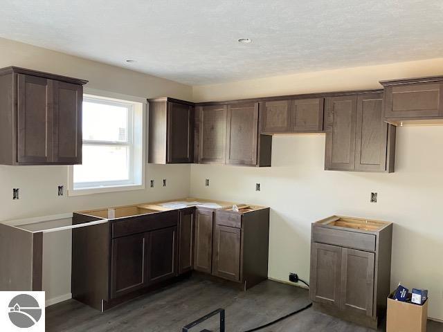 kitchen with dark brown cabinets and dark wood-type flooring