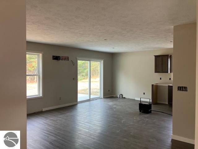 unfurnished living room featuring dark hardwood / wood-style floors and a textured ceiling