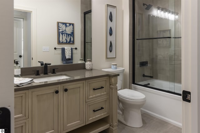 full bathroom featuring toilet, tile patterned floors, vanity, and shower / bath combination with glass door