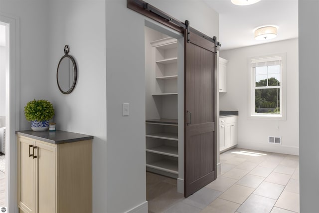 interior space featuring light tile patterned floors and a barn door