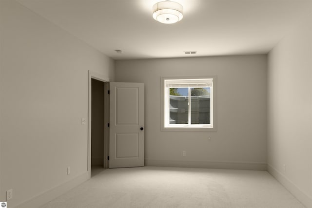 unfurnished room featuring light colored carpet