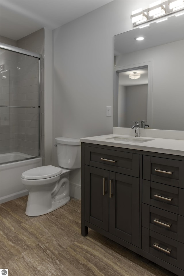 full bathroom with hardwood / wood-style flooring, enclosed tub / shower combo, toilet, and vanity