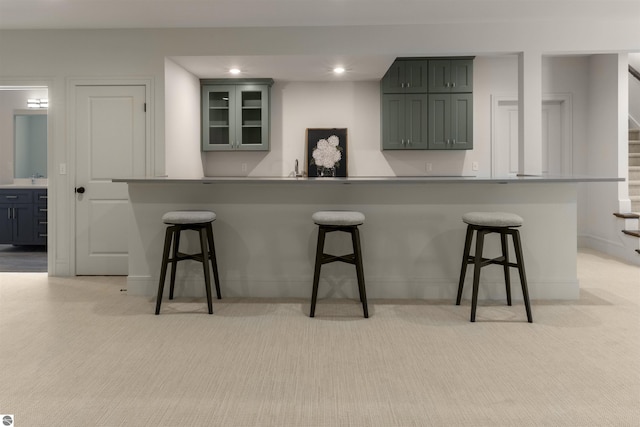 kitchen with light colored carpet and a breakfast bar