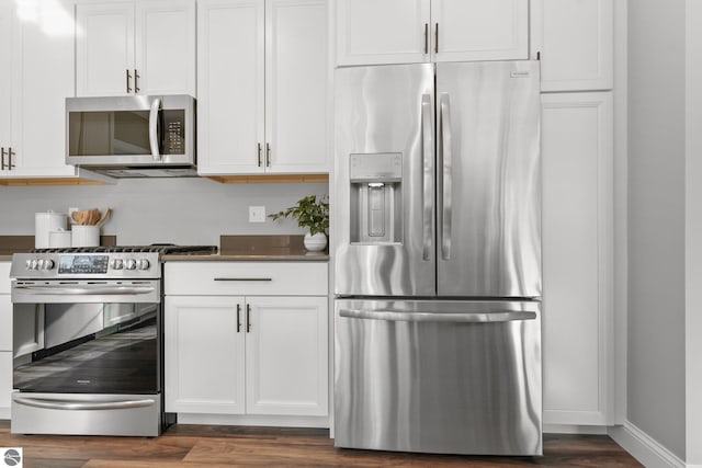 kitchen featuring dark hardwood / wood-style floors, appliances with stainless steel finishes, and white cabinetry