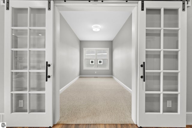 interior space with carpet floors and a barn door