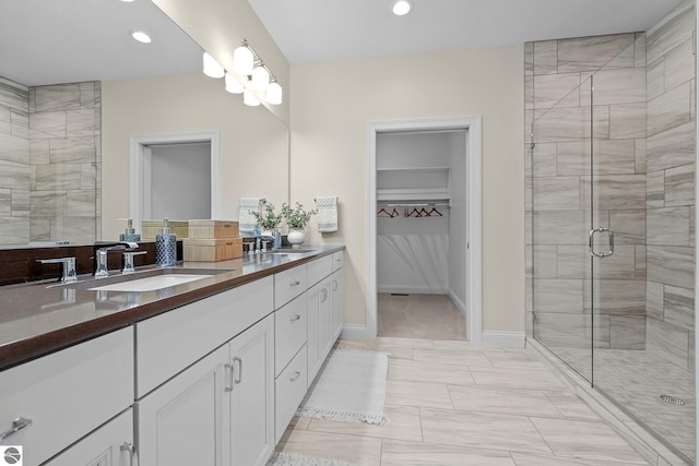 bathroom featuring a shower with shower door and vanity