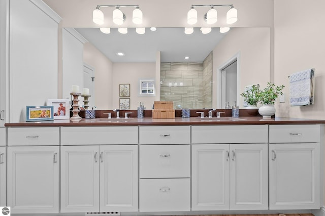 bathroom with a shower with shower door and vanity