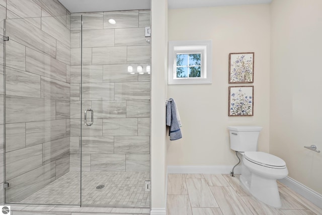 bathroom with toilet and a shower with shower door