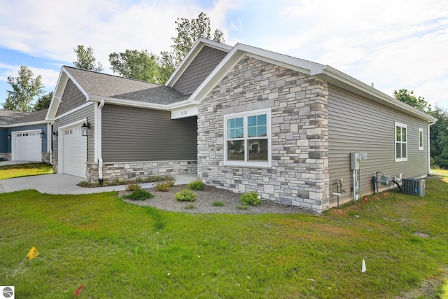 view of front of house featuring a garage, a front yard, and central AC unit