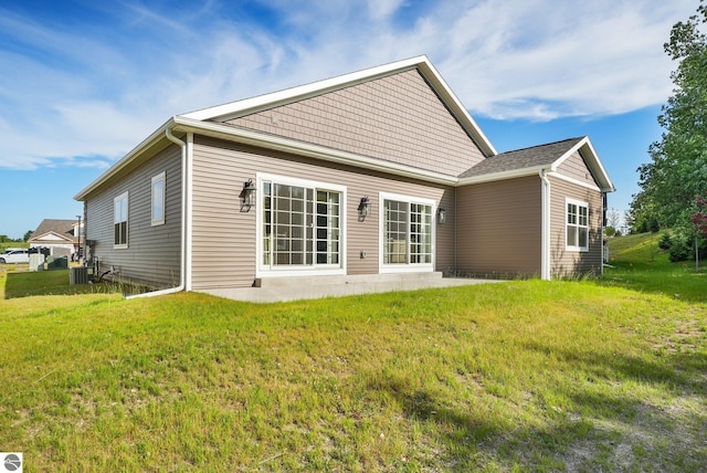 rear view of house with a yard and central AC unit