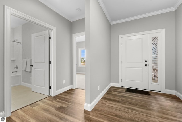 entryway with hardwood / wood-style floors and ornamental molding