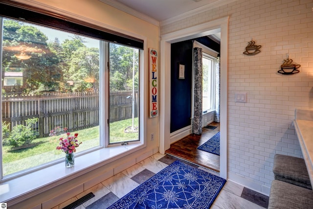 entryway featuring wood-type flooring, plenty of natural light, and crown molding