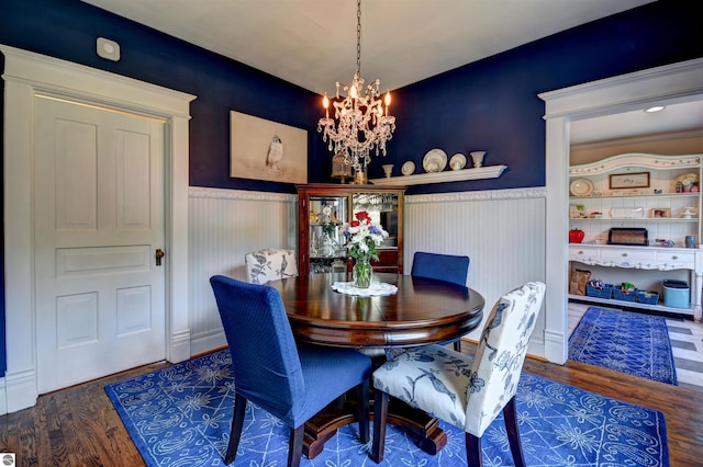 dining area with dark hardwood / wood-style floors and a notable chandelier