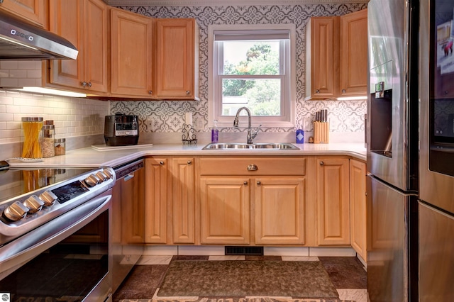 kitchen featuring backsplash, sink, dark tile patterned floors, range hood, and stainless steel appliances