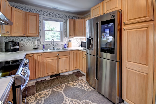 kitchen featuring dark tile patterned flooring, wall chimney range hood, sink, appliances with stainless steel finishes, and tasteful backsplash