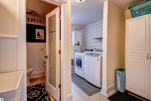 bathroom featuring toilet, washer and dryer, and hardwood / wood-style flooring