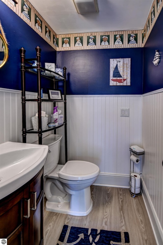 bathroom with hardwood / wood-style floors, vanity, and toilet