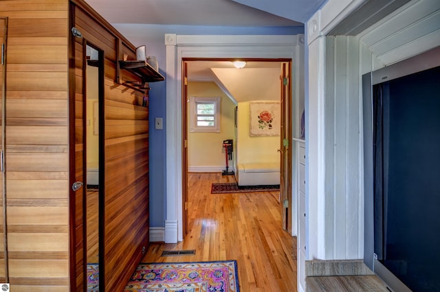 hall featuring wood walls and light hardwood / wood-style floors