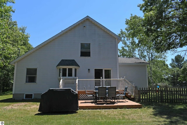 rear view of property featuring a yard and a deck