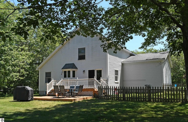 rear view of property with a deck and a lawn