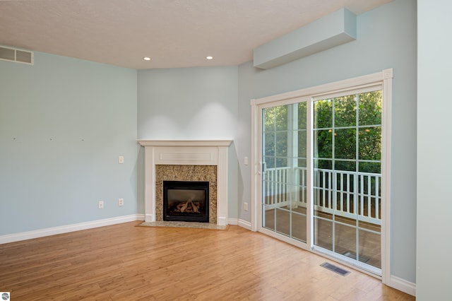 unfurnished living room featuring baseboards, visible vents, and wood finished floors