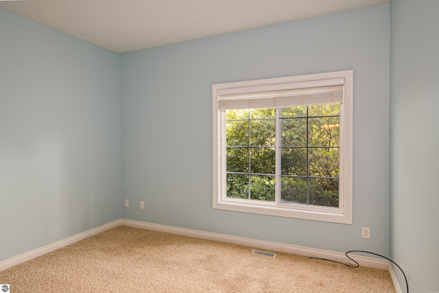 unfurnished room with visible vents, carpet flooring, and baseboards