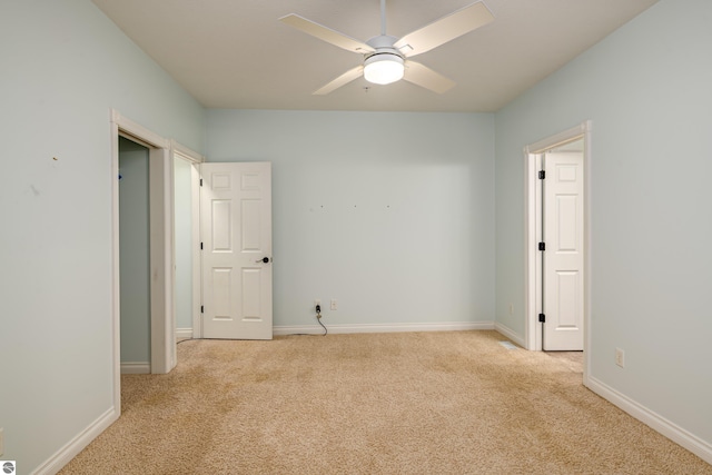 empty room featuring carpet floors, a ceiling fan, and baseboards