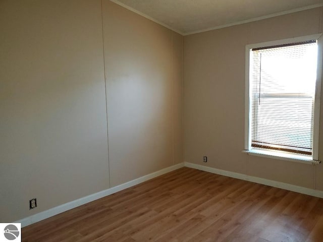 unfurnished room with light hardwood / wood-style floors and crown molding