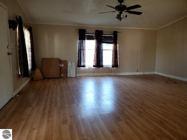 empty room with ceiling fan, wood-type flooring, and crown molding