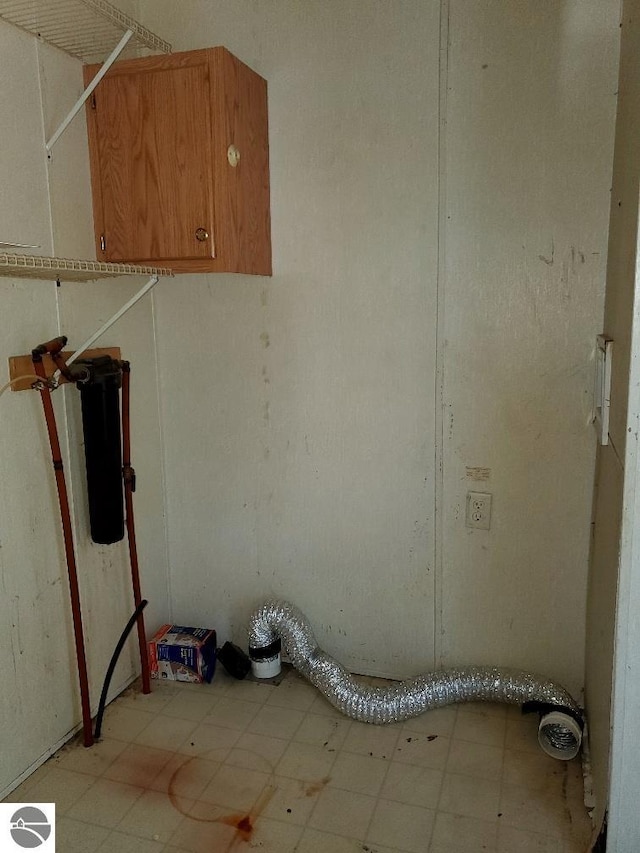 clothes washing area featuring cabinets