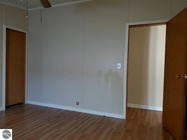 empty room with hardwood / wood-style floors and ceiling fan