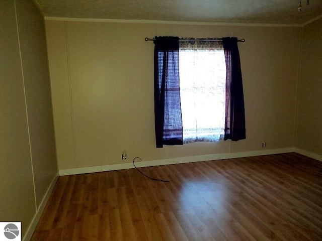 unfurnished room featuring crown molding and wood-type flooring