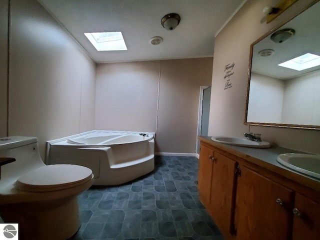 bathroom with vanity, toilet, a bath, and a skylight