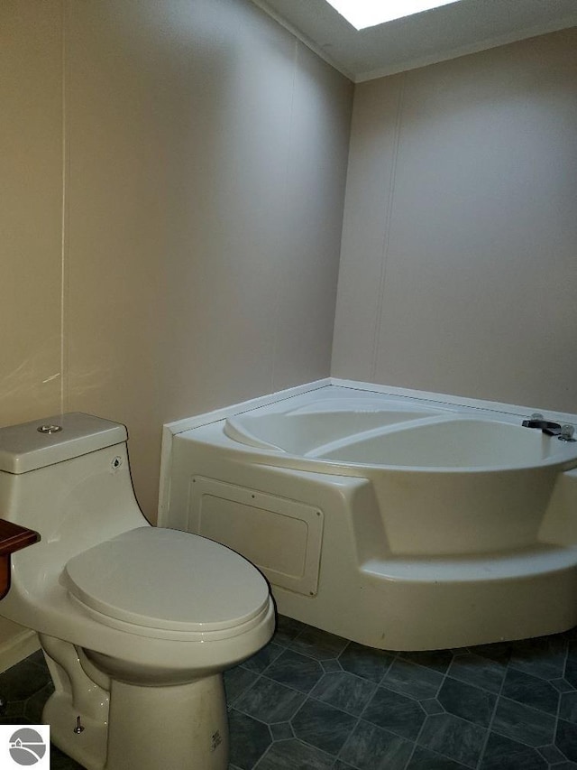 bathroom featuring a washtub, tile patterned flooring, and toilet