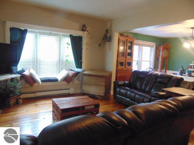 living room with a chandelier, light hardwood / wood-style floors, and baseboard heating