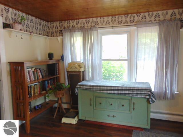 sitting room featuring dark hardwood / wood-style flooring, a baseboard heating unit, and wood ceiling